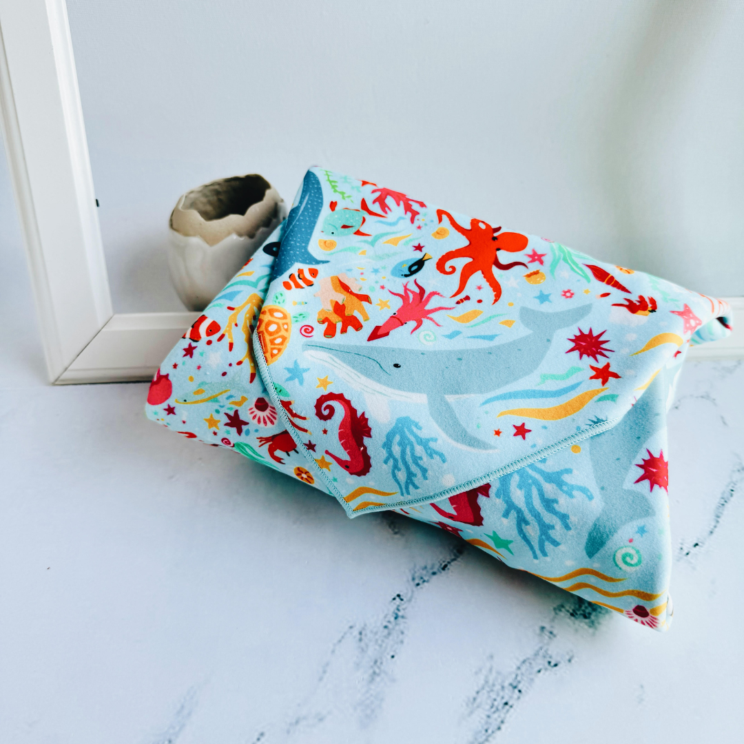 Tsutsumi Clingy Wrap with marine creatures artwork on light blue background, fully wrapping a box.
