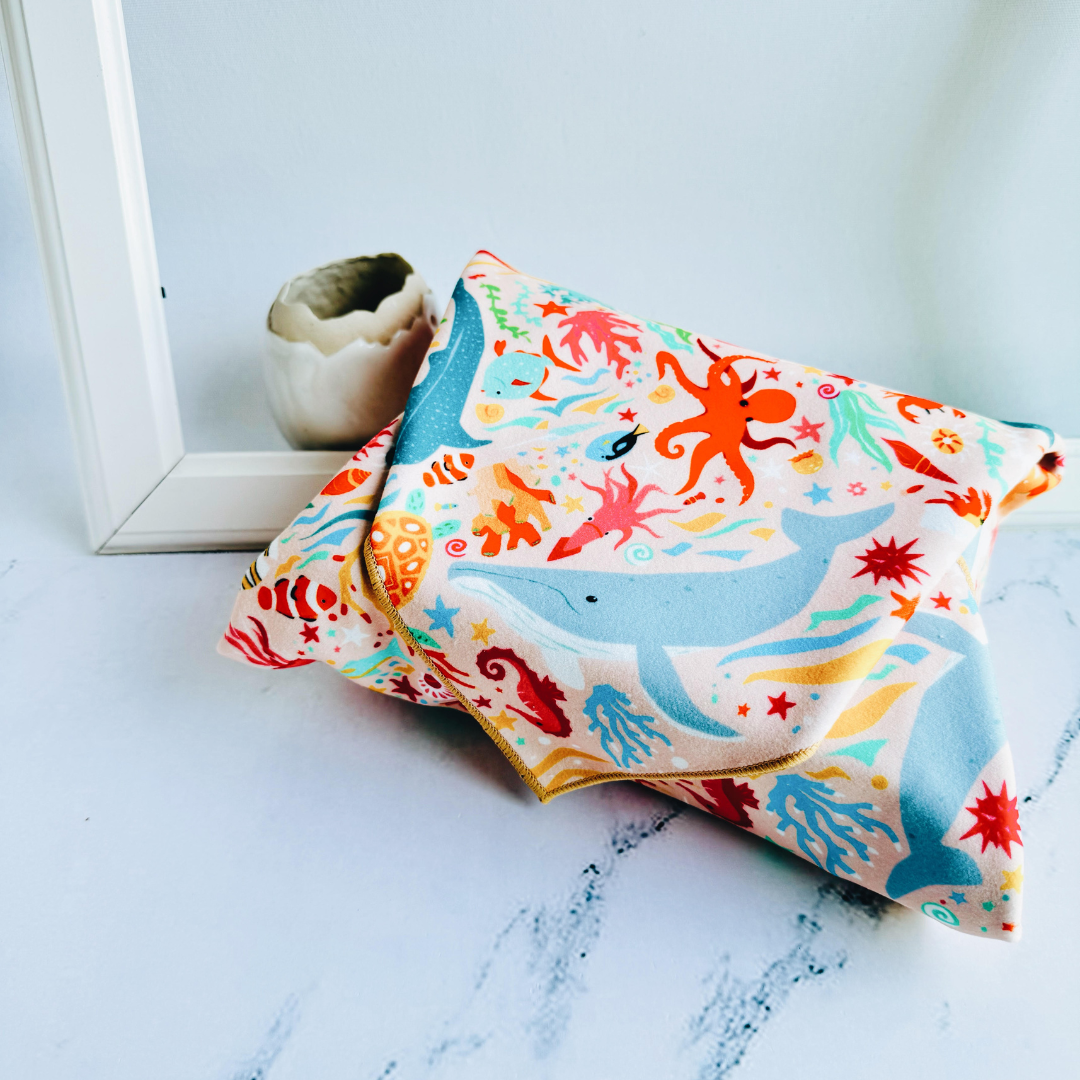 Tsutsumi Clingy Wrap with marine creatures artwork on light pink background, fully wrapping a box.