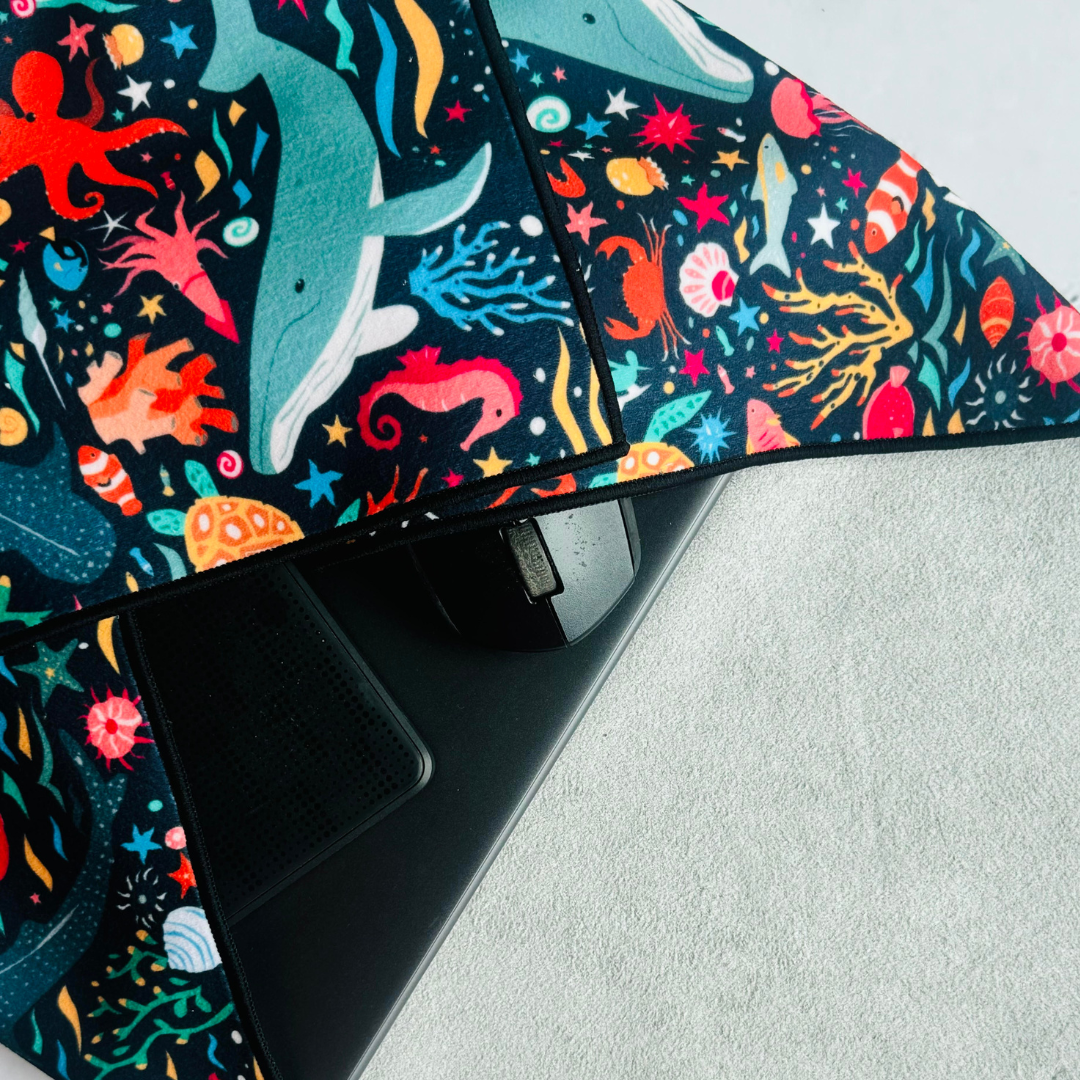 Clingy Wrap in marine fantasy print, covering a laptop, mouse and external harddisk