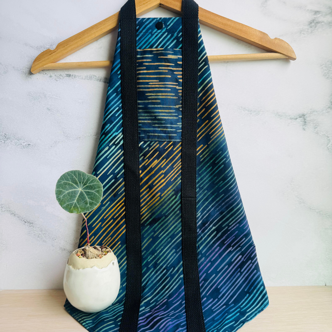 Navy fabric Square Wrap hung from a hanger