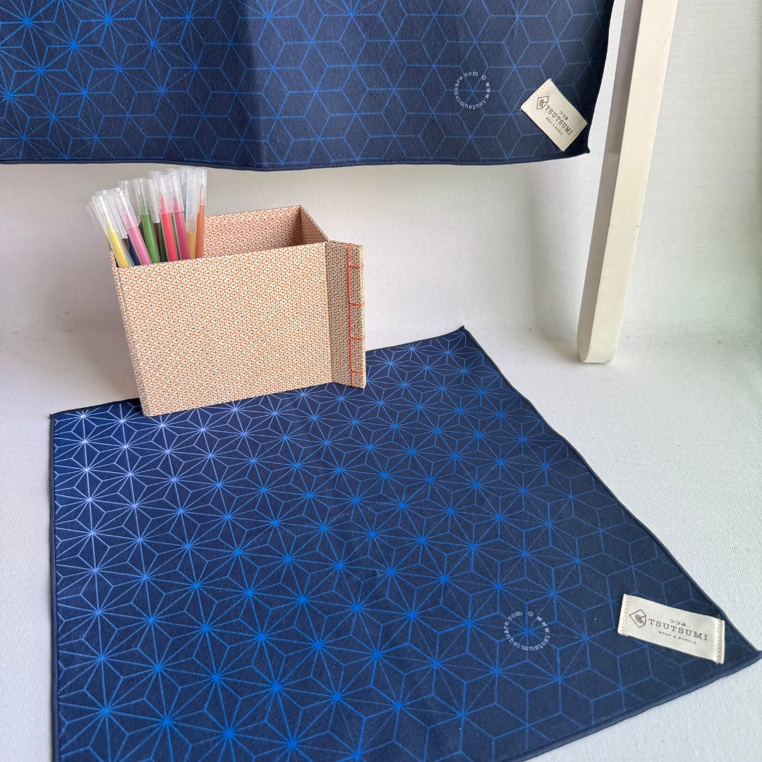 Blue geometric patterned fabric with a box of markers on a white surface