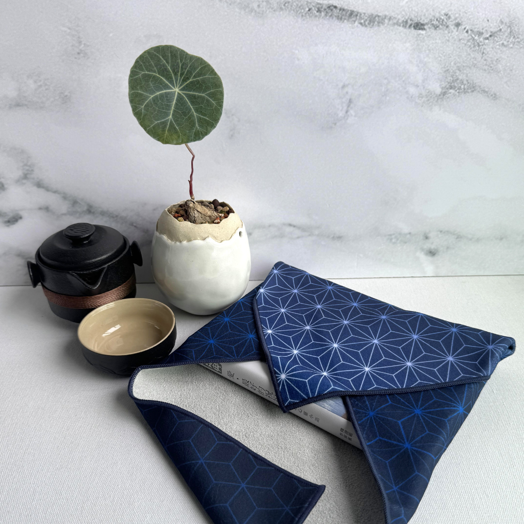 Blue geometric patterned fabric wrap on a marble surface with a small plant and teapot