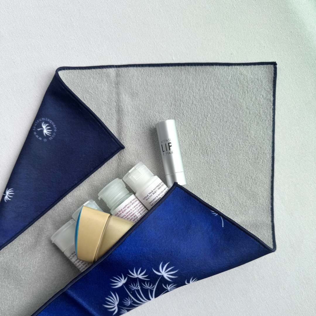 Blue patterned fabric wrap with dandelion pattern holding skincare products