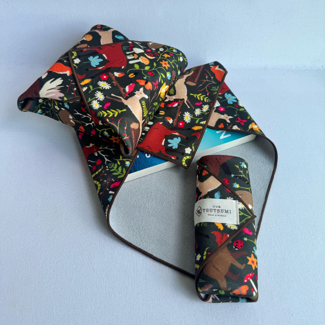3 pieces of fabric with Woodland Fantasy print in dark green background each wrapping different items.