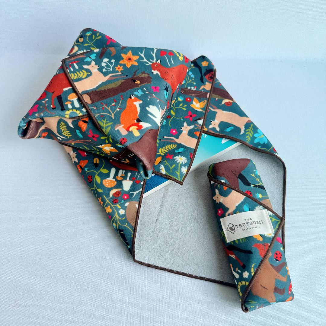 3 pieces of fabric with Woodland Fantasy print in dark teal background each wrapping different items.