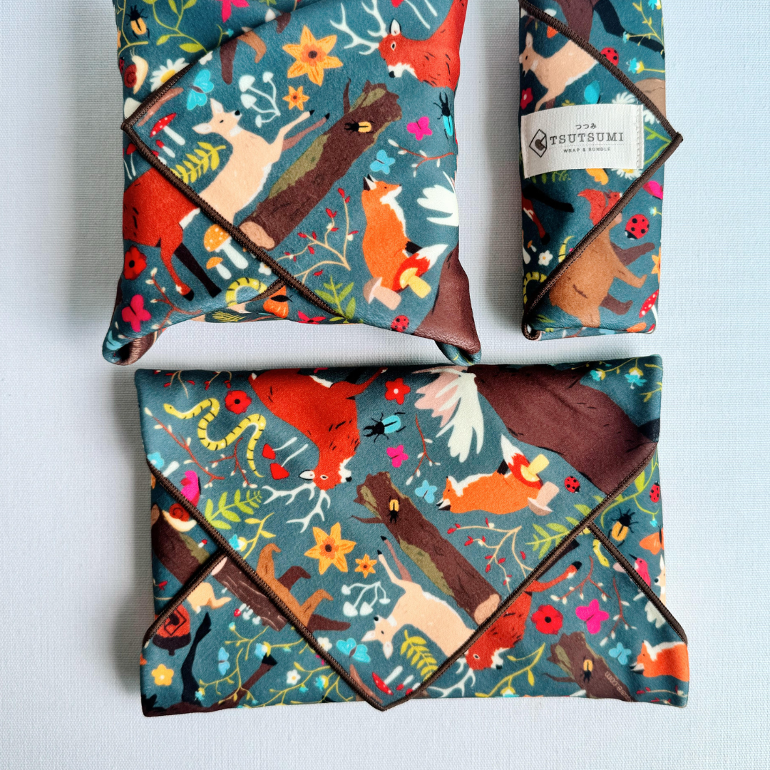 3 packages wrapped with fabric with Woodland Fantasy print in dark teal background.