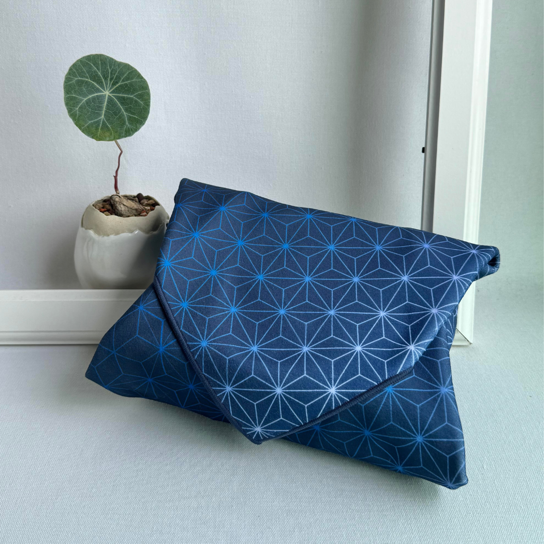 Blue Asanoha geometric patterned fabric wrapping a package with a plant in the background