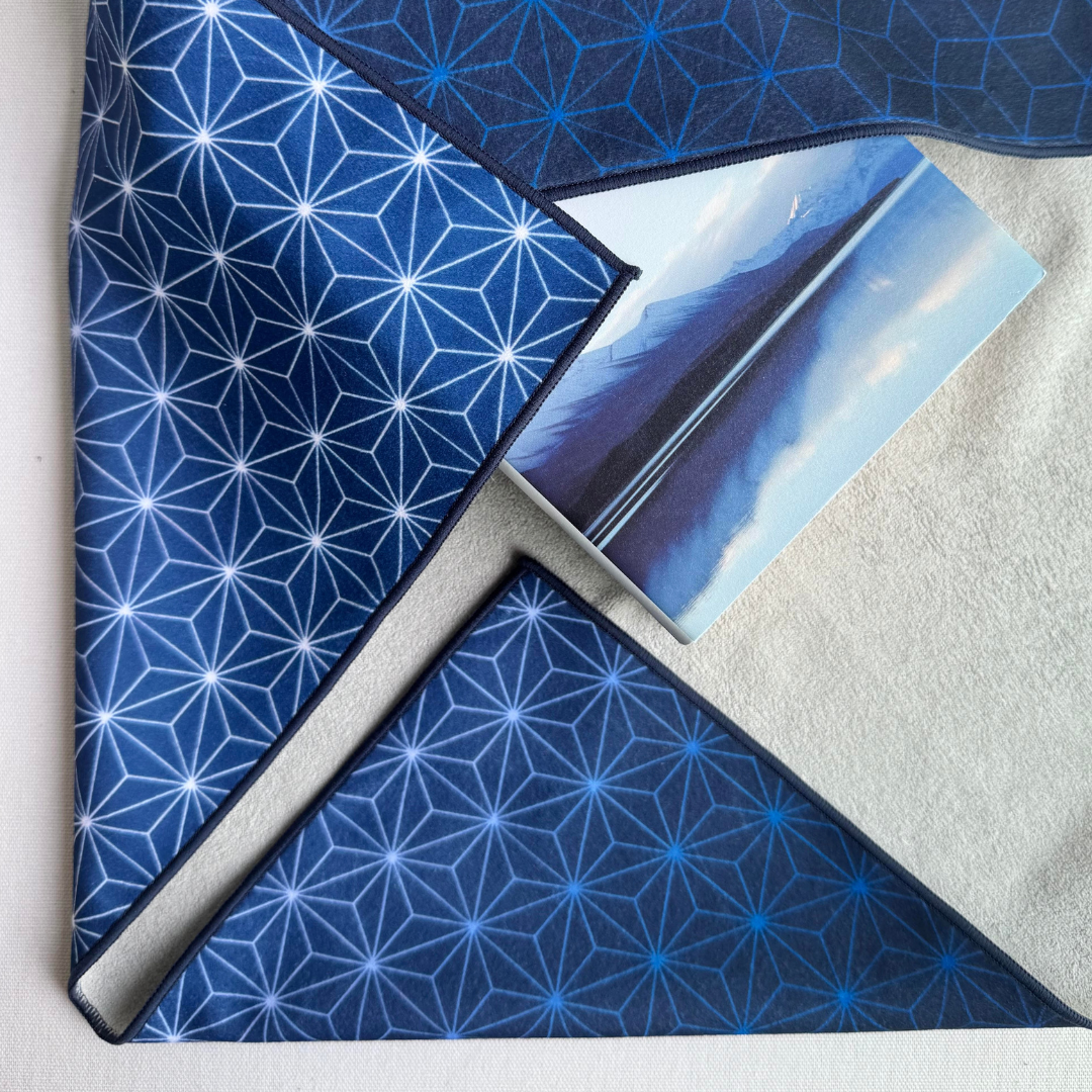 Blue Asanoha geometric patterned fabric wrap holding a book with a mountain scene on the cover