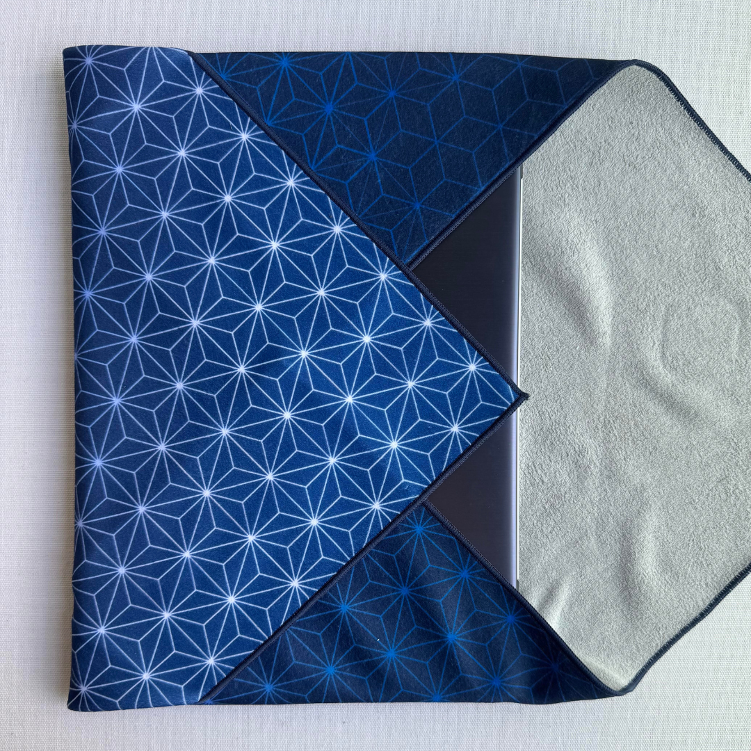 Folded blue fabric with Asanoha geometric pattern holding a laptop on a white background