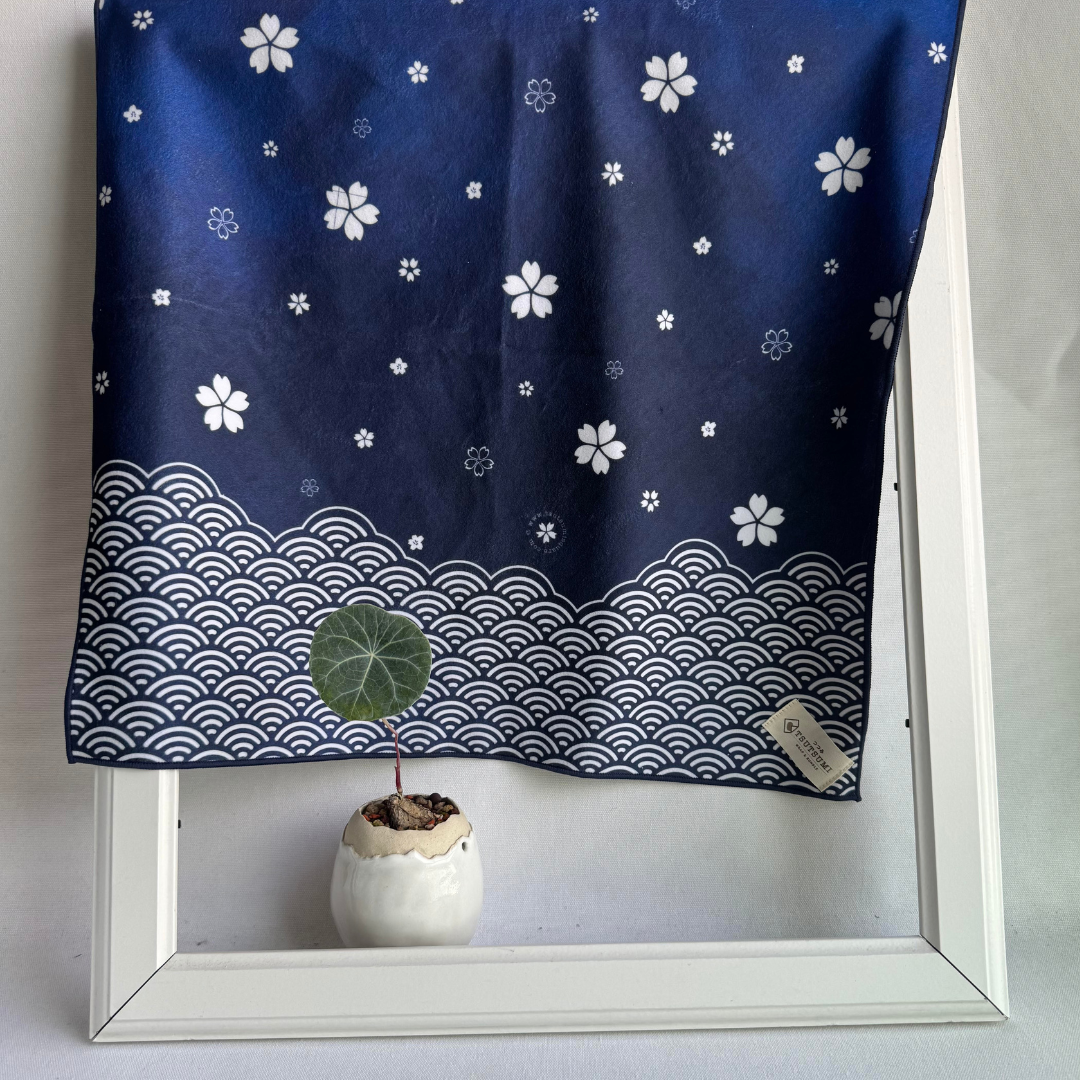 Navy blue fabric with white sakura and seigaiha patterns draped over a white frame with a plant inside.