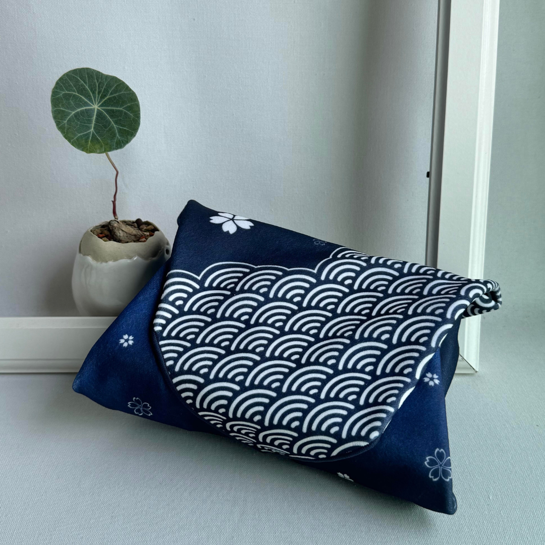 Blue sakura and seigaiha patterned wrapping a package with a plant in the background