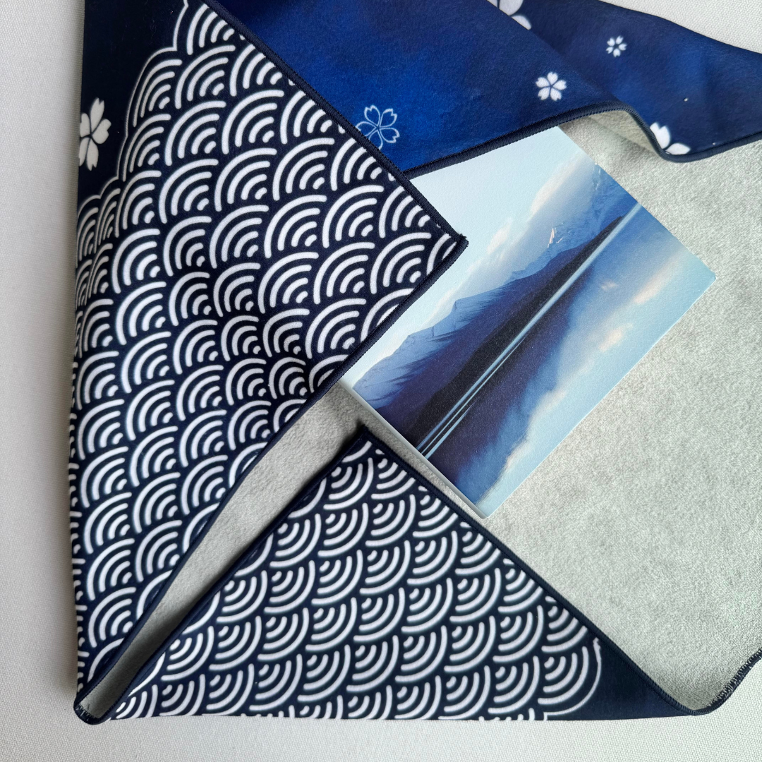 Blue sakura and seigaiha geometric patterned fabric wrap holding a book with a mountain scene on the cover