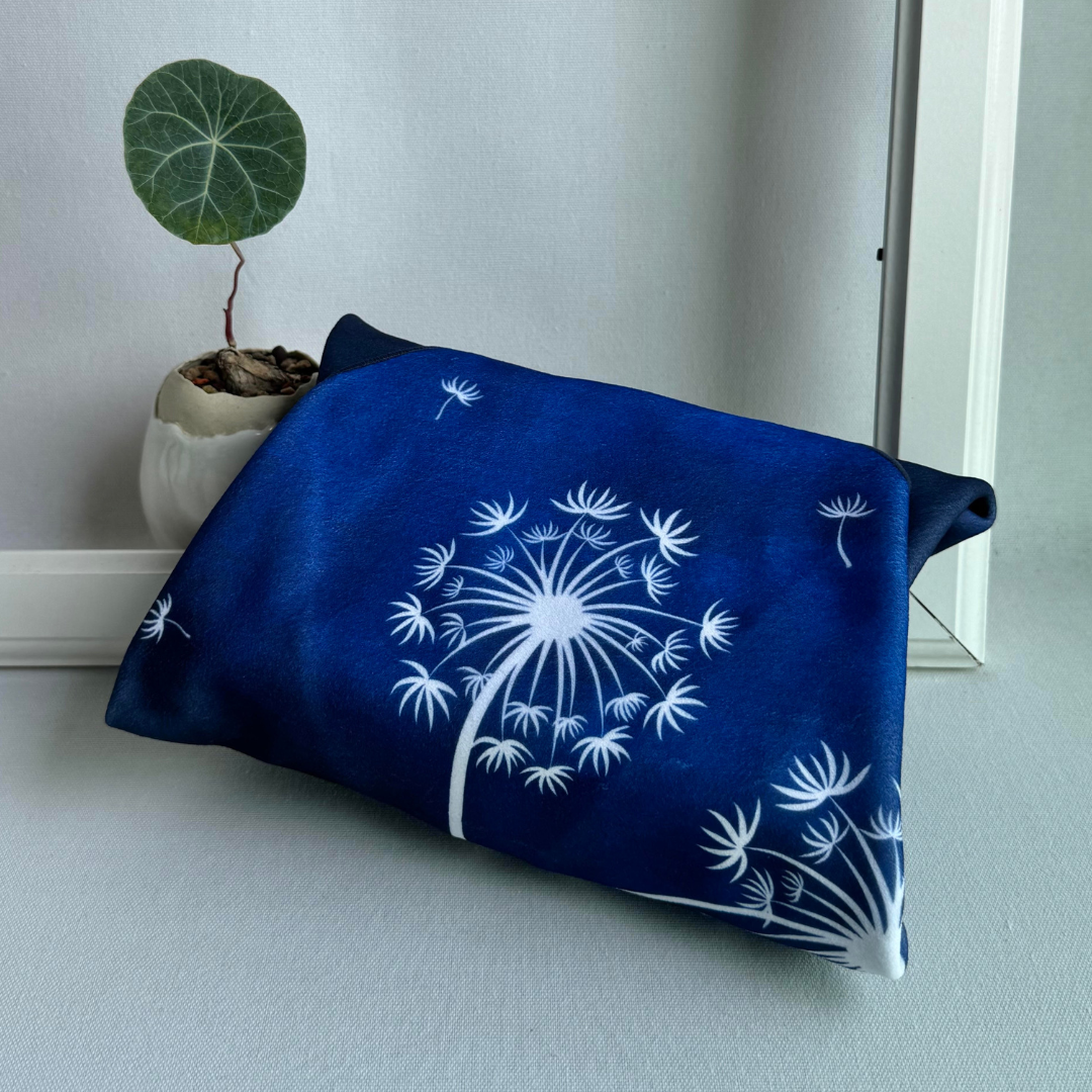 Blue Tanpopo (dandelion) geometric patterned wrapping a package with a plant in the background