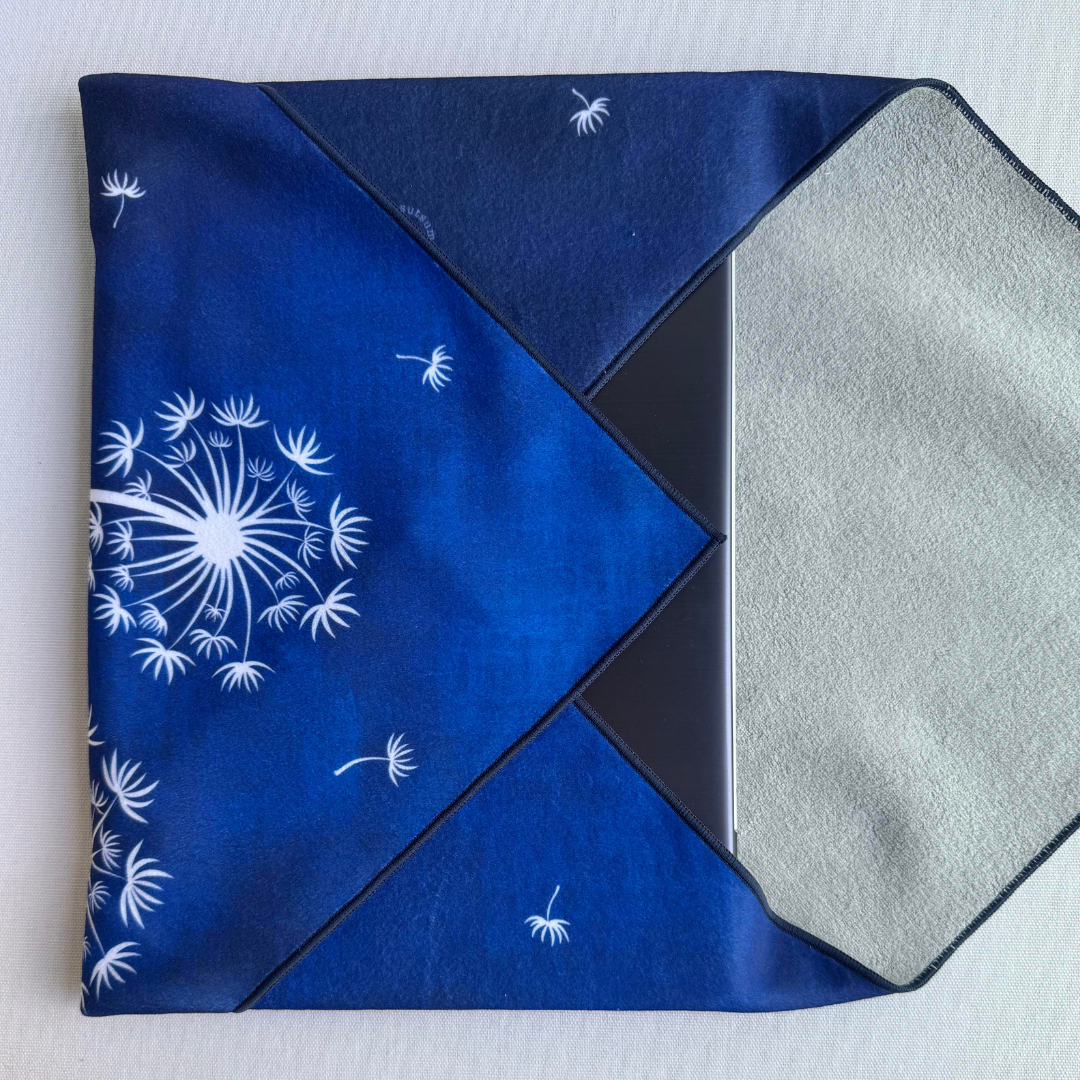Folded blue fabric with Tanpopo (dandelion) pattern holding a laptop on a white background