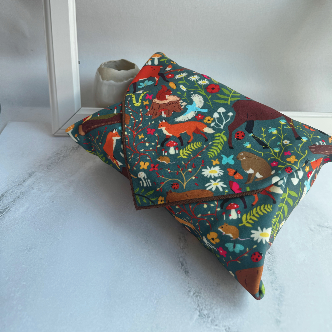 Tsutsumi Clingy Wrap with woodland creatures artwork on dark teal background, fully wrapping a box.