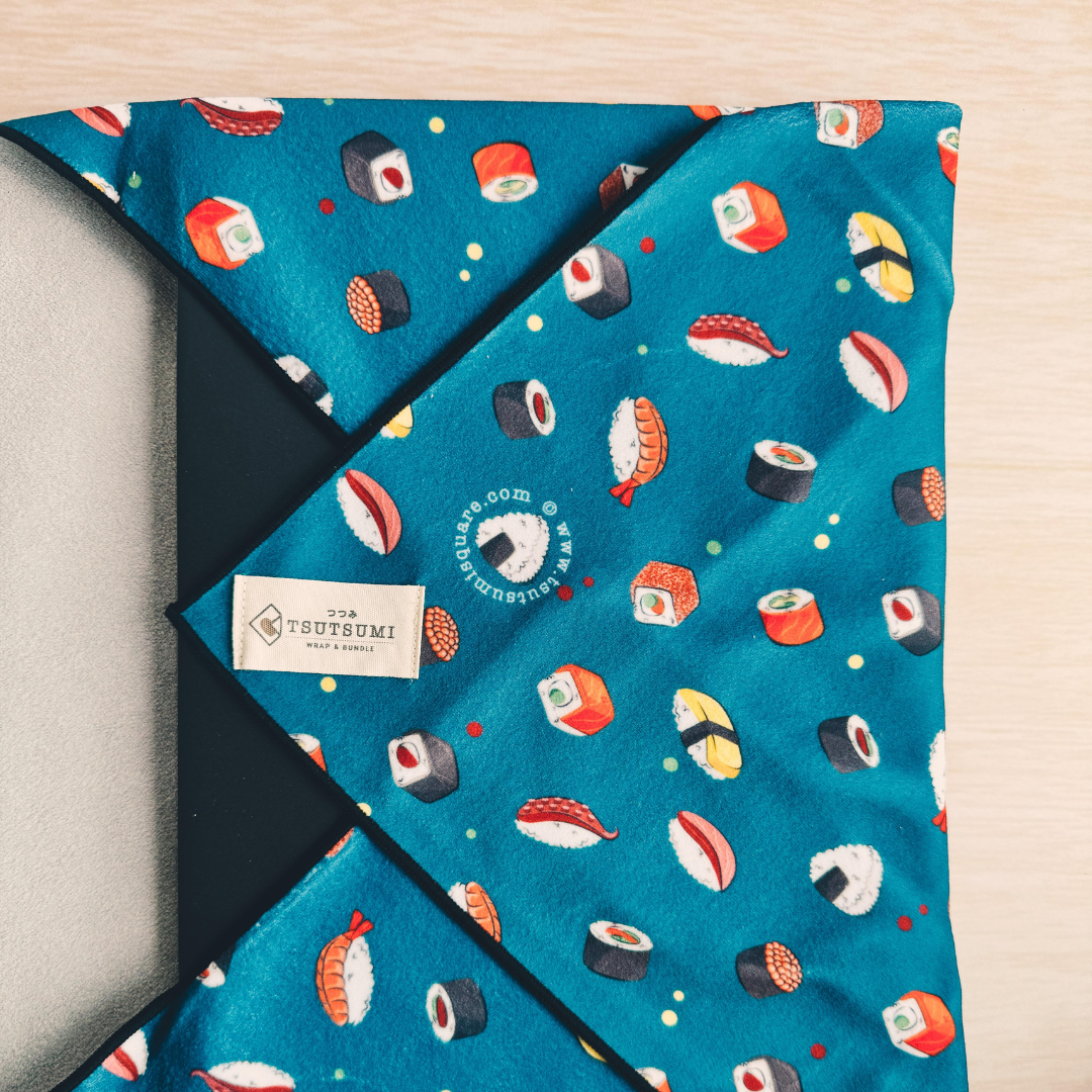 Dark Teal fabric with sushi pattern and Tsutsumi brand label wrapping a laptop