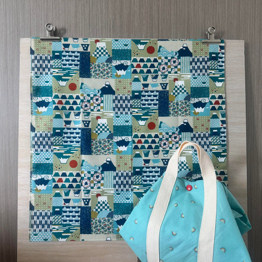 Fabric with Mount Fuji icons and teal background, and Tsutsumi square wrap used for wrapping a lunchbox