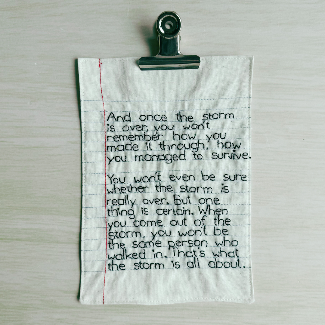 Text on a piece of lined fabric clipped to a wooden surface