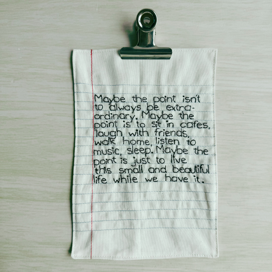 Text on a piece of lined fabric clipped to a wooden surface