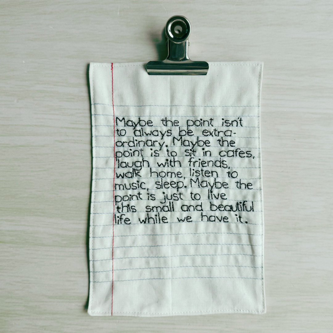 Text on a piece of lined fabric with a binder clip