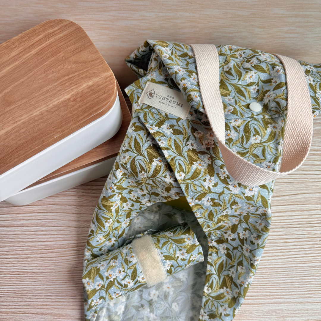 Floral-patterned fabric square wrap next to two wooden lid containers