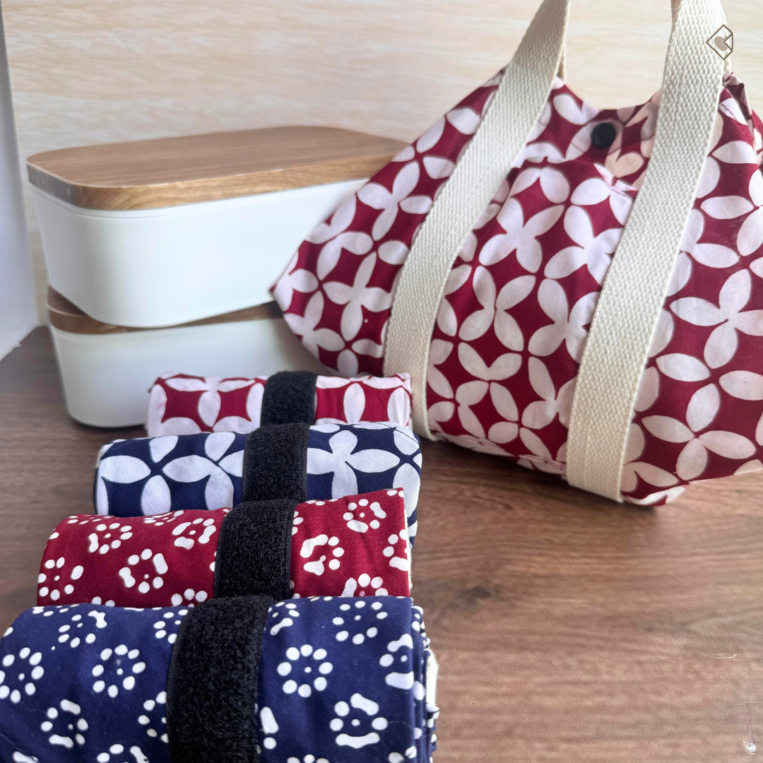 Set of patterned bags on a wooden surface with a wooden container in the background.
