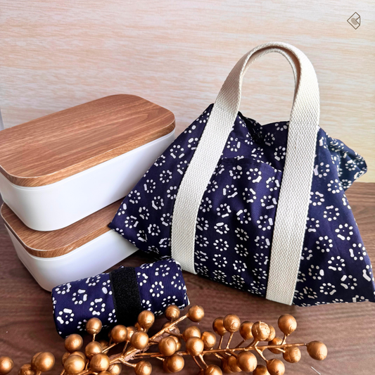 Navy floral-patterned bag with beige handle next to white containers with wooden lids on a wooden surface.